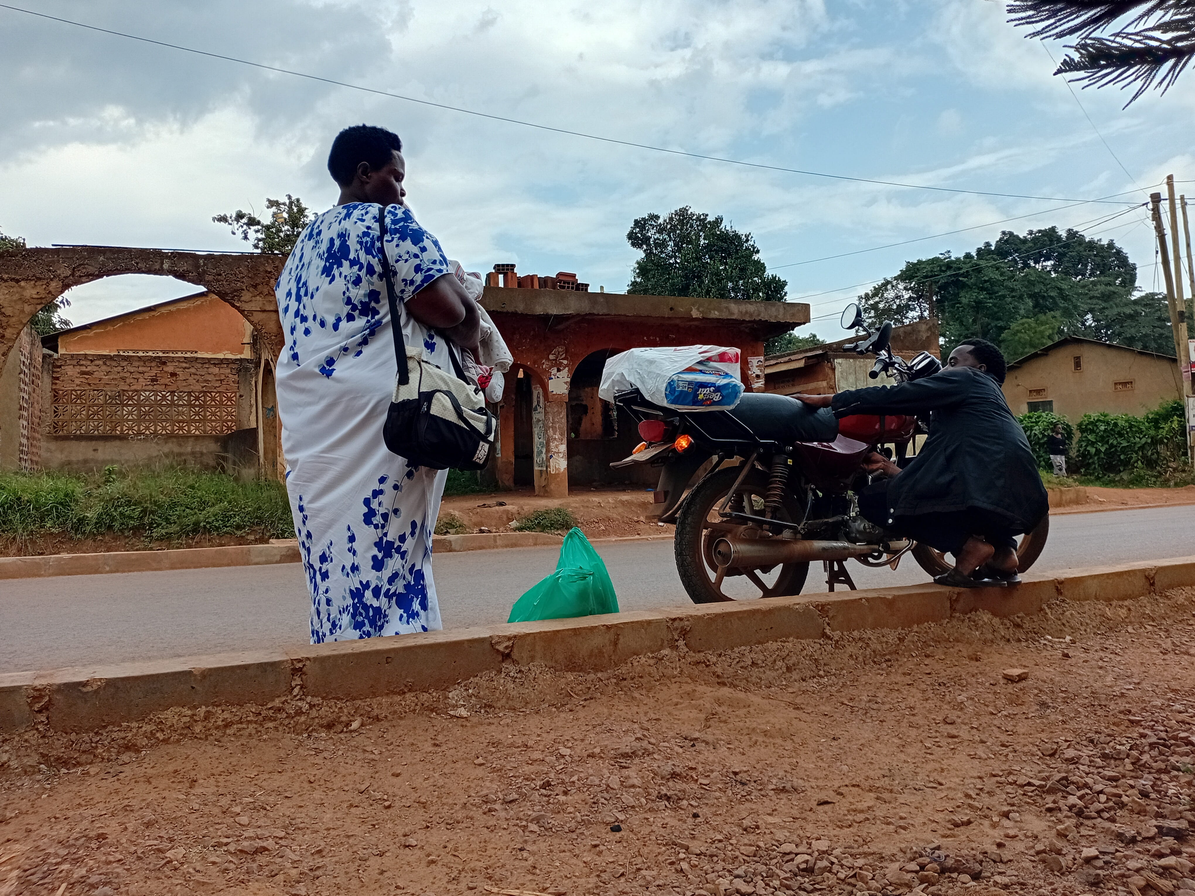 A mother and child wait as donated supplies are loaded for delivery.
